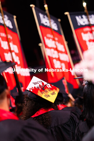 A graduate's cap reads "you're either in or in the way" during the summer commencement ceremony. Sum