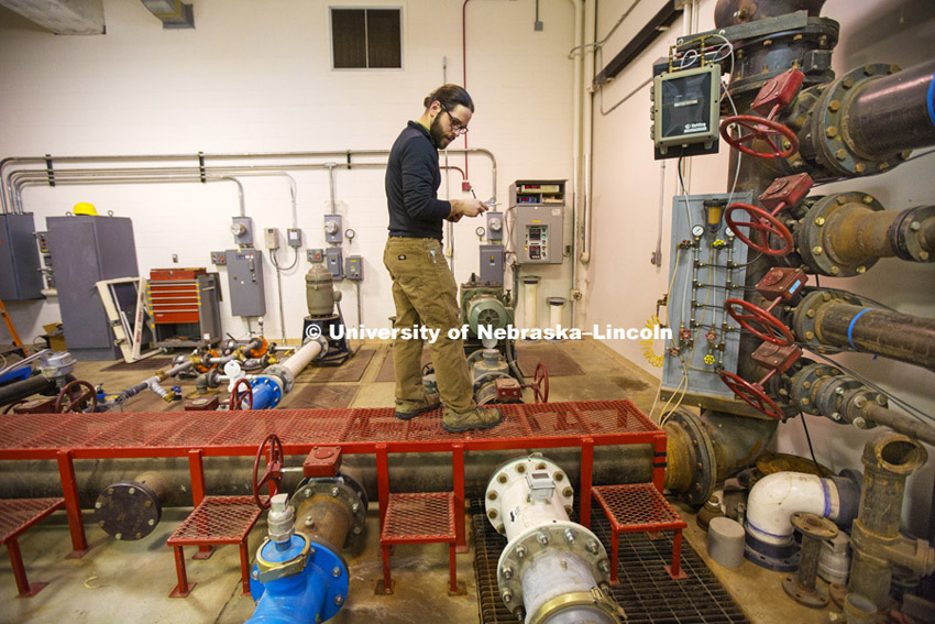 Isaiah Krutak works on testing a flow meter in the Hydrology Lab in Chase Hall on East Campus.  February 18, 2015. Photo by Craig Chandler / University Communications. 