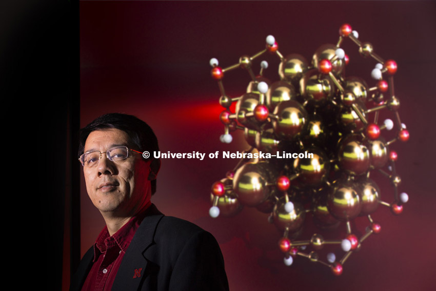 Xiao Zeng, Professor of Chemistry, Physics & Astronomy stands before a rendering of the gold nano particles. April 13, 2015. Photo by Craig Chandler / University Communications