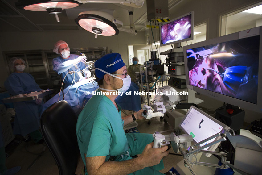 Dmitry Oleynikov, a professor and surgeon at the University of Nebraska Medical Center, operates a surgical robot as in the background Shane Farritor, an engineering professor at the University of Nebraska-Lincoln, adjusts the camera on the surgical subject. The two developed the robot for minimally invasive surgeries. June 16, 2015.  Photo by Craig Chandler / University Communications