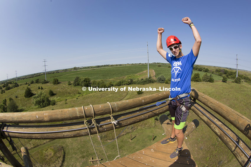 Jacob Rehwoldt celebrates from the top of Alpine Tower. Raikes School students spend the day at Campus Recreation's Challenge Course northwest of town doing activities including climbing a 50-foot tower.  Friday, August 21, 2014. Photo by Craig Chandler / University Communications