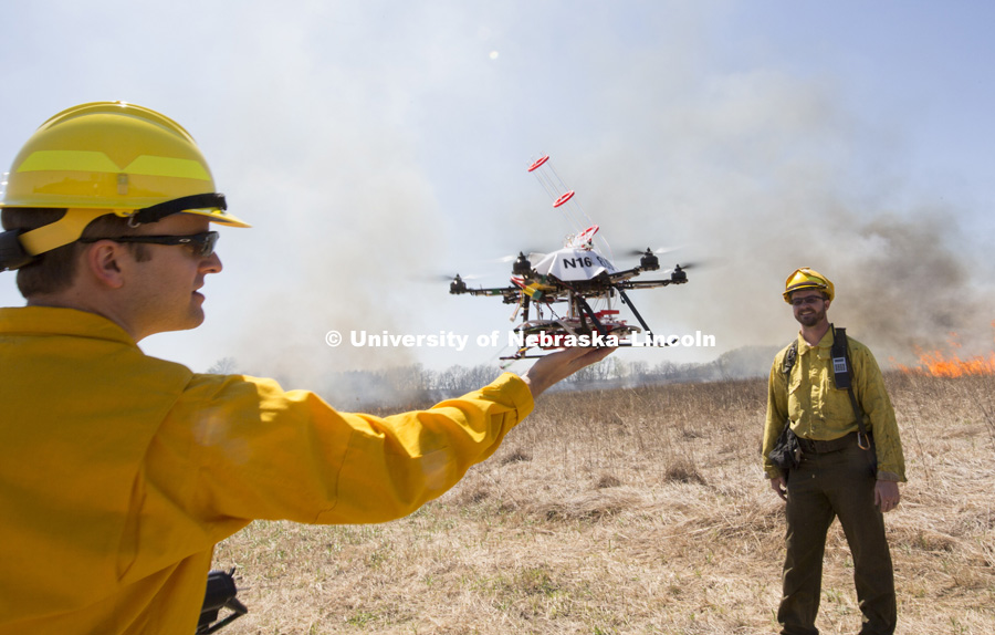 Professor Carrick Detweiler snatches the drone in mid air after it’s last flight as Professor Dirac Twidwell looks on.  UNL researchers use a small drone to set prairie burn at Homestead National Monument in Beatrice, NE. April 22, 2016. Photo by Craig Chandler / University Communications