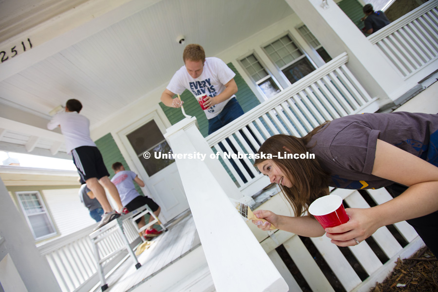 Kate Christensen from Utah works on a porch rail while her husband, L1 law student Theron Christensen works on the porch column at a house on B Street. Students, faculty and staff from the College of Law participated in the city-wide Paint-A-Thon by painting four houses. August 20, 2016. Photo by Craig Chandler / University of Nebraska