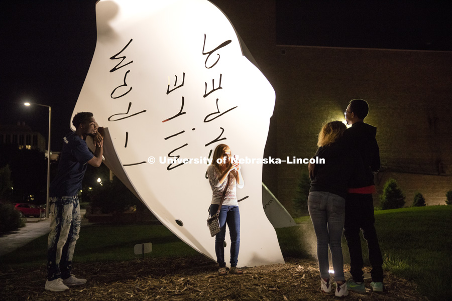 Alisha Botts of Lincoln, takes a photo of her friends in front of the Torn Notebook sculpture on city campus Friday evening. September 2, 2016.  Photo by Craig Chandler / University Communication Photography.