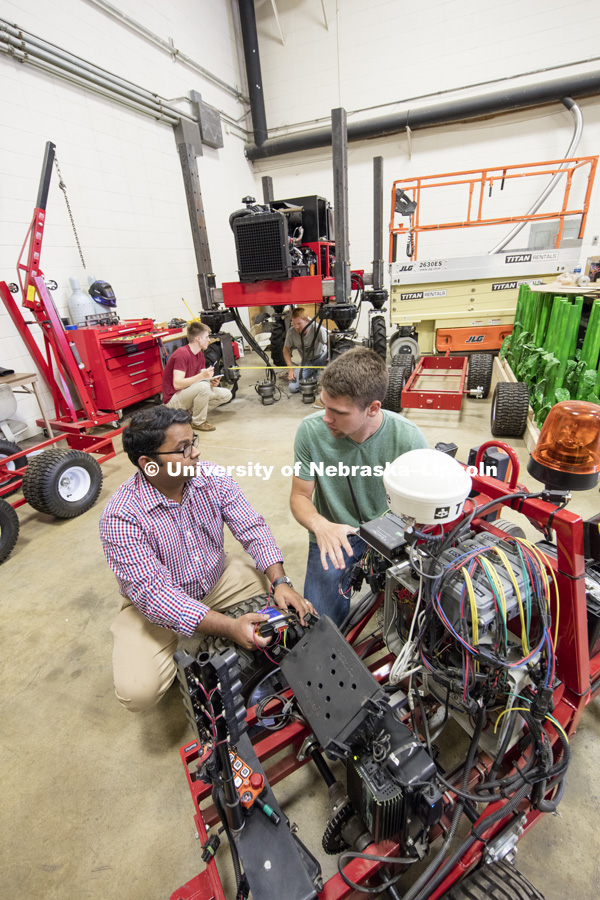 Santosh Pitla discusses the electronics on a robotic cart with Tyler Troyer, graduate student in BSE. Robotics lab on east campus. Biological Systems Engineering. August 15, 2016. Photo by Craig Chandler / University Communication.