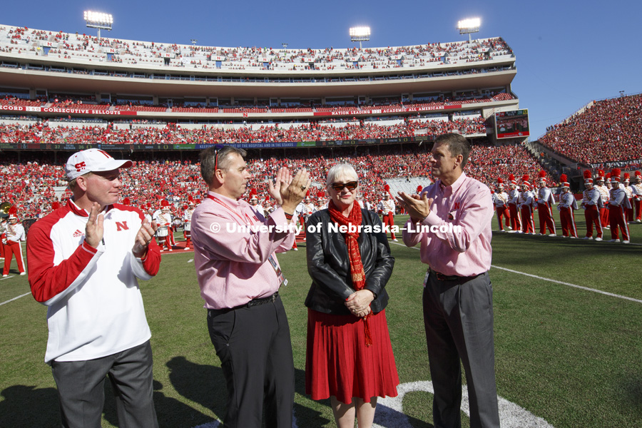 Missi Paul is applauded by Director of Atheltics Shawn Eichorst, left, University of Nebraska Chancellor Ronnie Green and NU President Hank Bounds as she and her late husband, Prem Paul, were honored on the field for the amazing impact Prem Paul had as Vice Chancellor for Research. Nebraska vs. Oregon football. September 17, 2016. Photo by Craig Chandler / University Communication Photography.