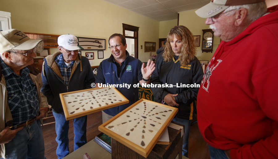 Dennis Kuhnel, director of the U.S. Forestry Service's National Grassland Visitors Center, describes the unusual pieces of a collection brought in by Chuck Anders, wearing Husker sweatshirt, and his daughter Jennifer Peters, at right. Artifacts Road Show put on by UNL Professor Matt Douglass and the U.S. Forestry Service in Mullen, NE. October 7, 2016. Photo by Craig Chandler / University Communication Photography.