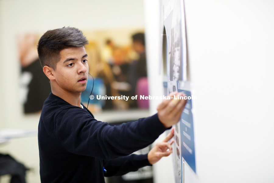 Eric Adame, freshman in architecture, hangs a class project in the Nebraska Union. January 24, 2017. Photo by Craig Chandler/University Communication.