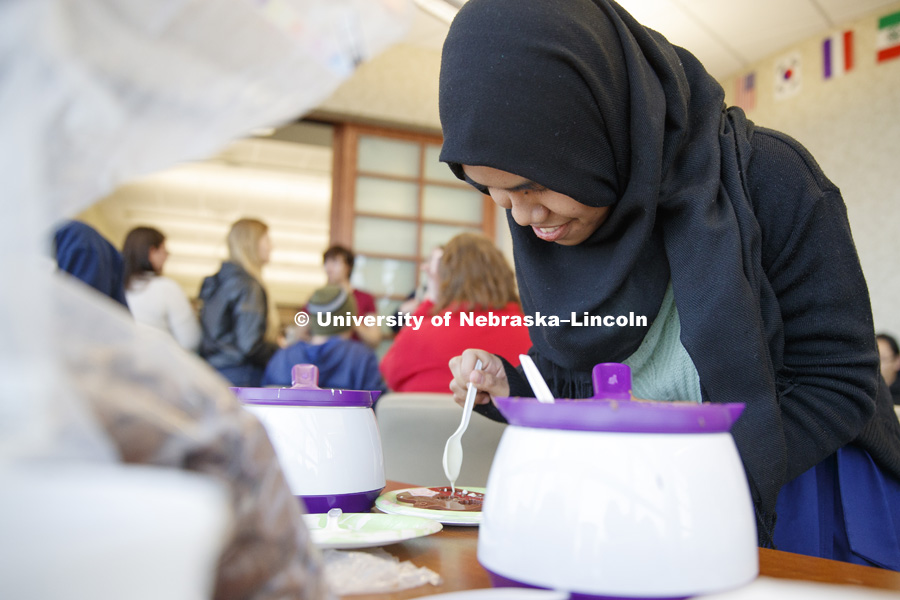 NurFathiah Izzaty spoons chocolate into molds Tuesday. Chocolate making in the Kawasaki Reading Room. February 14, 2017. Photo by Craig Chandler / University Communication.