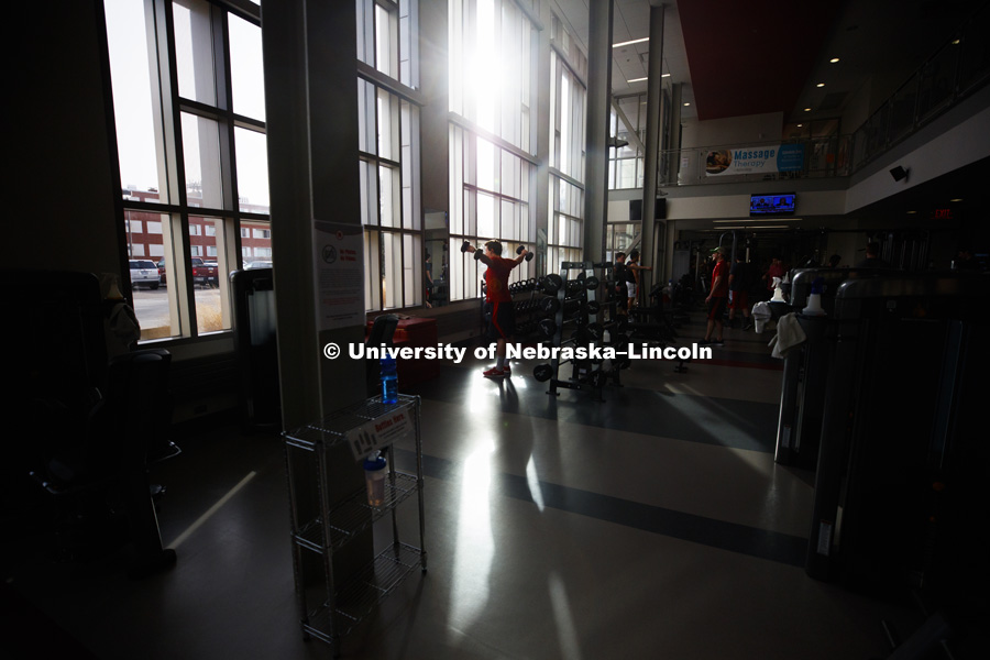 A shaft of light highlights Cooper Hicks working out in the East Campus Recreation Center. March 6, 2017. Photo by Craig Chandler / University Communication.