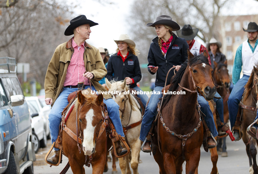 Governor Pete Ricketts talks with Kara Robbins, a barrel racer with the rodeo team, as the Governor rides with the University of Nebraska-Lincoln rodeo team on the streets around the Governor's Mansion. He rode a horse named Reuben with the team to