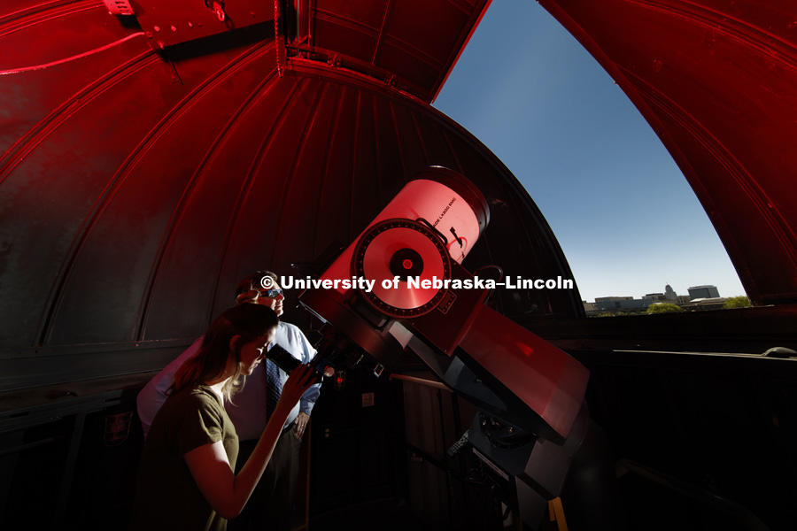 In the observatory atop the stadium parking garage, Hannah Paxton, senior in advertising and marketing, and Teaching Assistant for Professor Sibbernsen, eyes the skies under the supervision of Michael Sibbernsen, Lecturer of Astronomy- University of