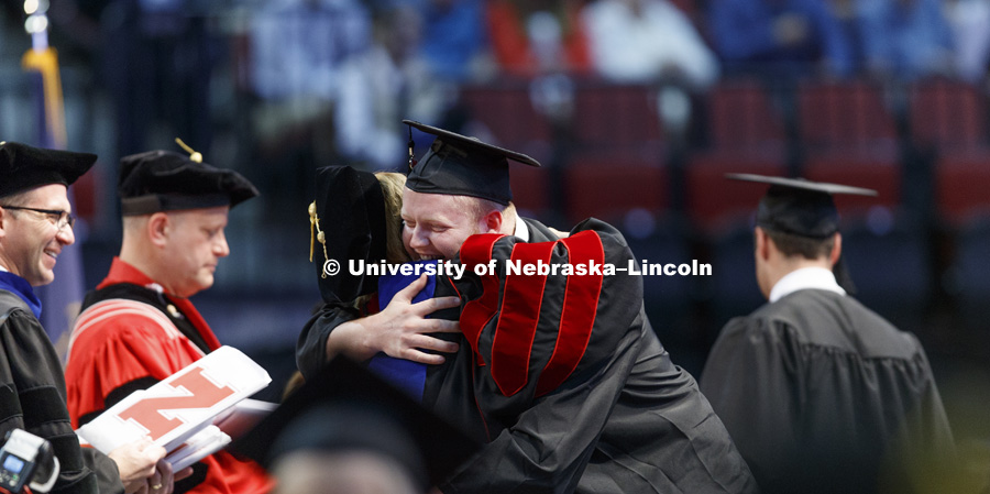 Jack Moylan hugs Interim Dean Kathy Farrell after receiving his College Business diploma. Students received their undergraduate diplomas Saturday morning in Lincoln's Pinnacle Bank Arena. 2452 degrees were awarded Saturday morning. May 6, 2017. Photo by