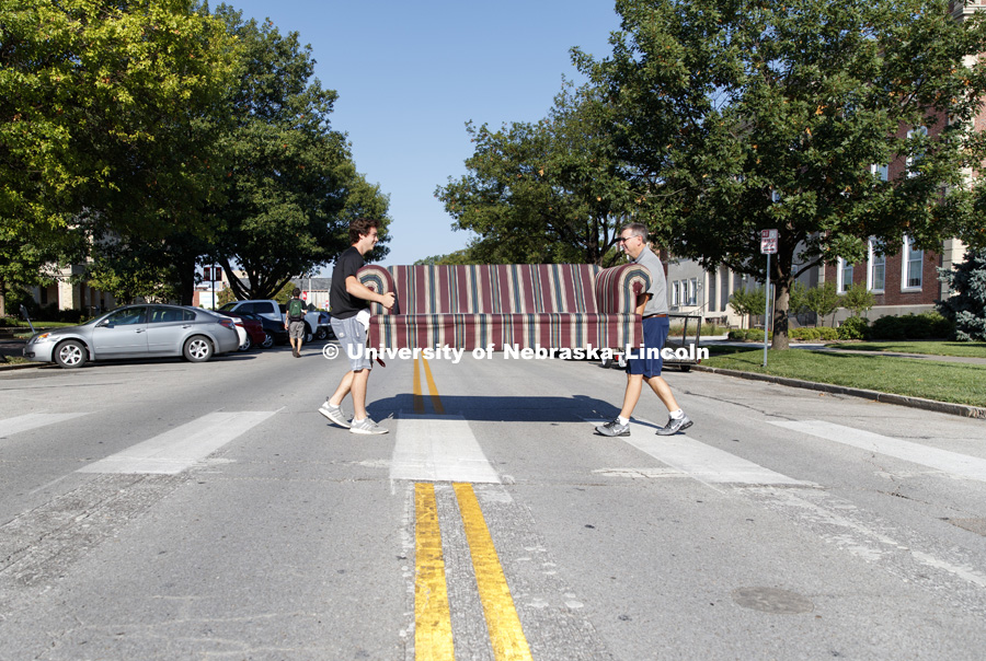 Luke Jarecke and his dad, Greg, carry a couch across R Street on their way to Beta Theta Pi fraternity. August 17, 2017. Photo by Craig Chandler / University Communication.