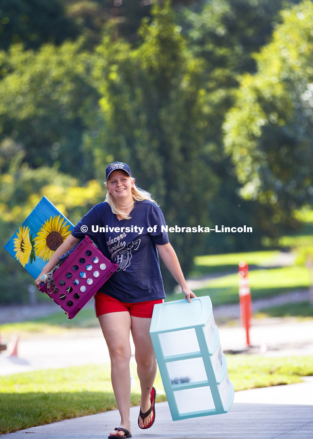 Cadrien Livingston carries some decorations into the new Massengale Residence Center Thursday morning. August 17, 2017. Photo by Craig Chandler / University Communication.
