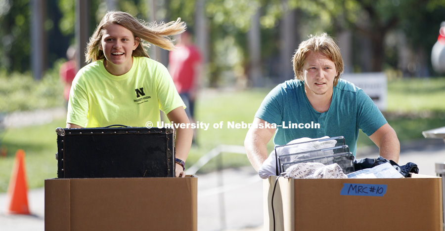 Transfer student William Roe and housing volunteer helper Brianna Smith push carts of Roe's belongings toward the new Massengale Residence Center. August 17, 2017. Photo by Craig Chandler / University Communication.