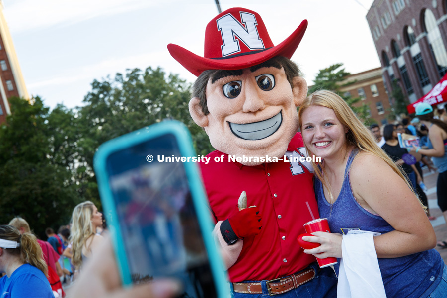 Kristin Rice, a junior from Neligh, NE, poses with Herbie Husker at the Street Festival between the College of Business and Memorial Stadium as part of the Big Red Welcome. August 20, 2017. Photo by Craig Chandler / University Communication.