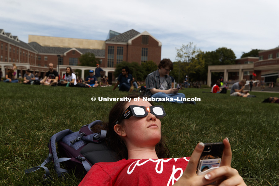 Ryket Thomas of Lincoln found a good spot and was watching the first part of the eclipse at 12:02 pm. Students gather on the green space between the Nebraska Union and the Raikes School to view the solar eclipse. August 21, 2017. Photo by Craig Chandler /