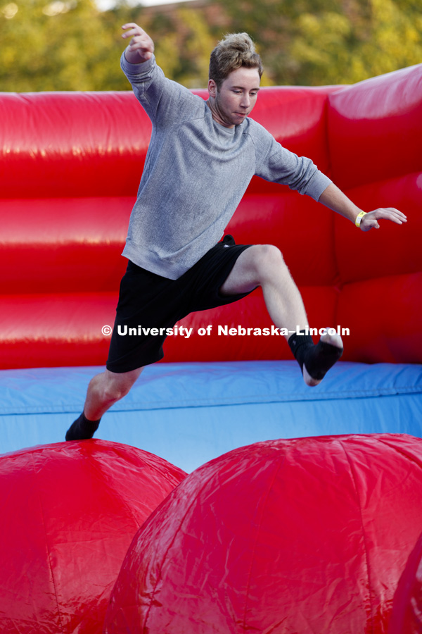Students leap, jump and bounce in the Leaps and Bounds, an obstacle course comprised of three inflated balls in an inflatable pit. Back to School Bash on the Nebraska Union Plaza and Green Space sponsored by Campus NightLife. Students enjoyed a headphone