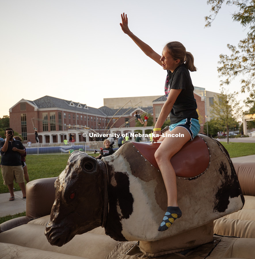 Holly Ecker gets an arm up as she rides the mechanical bull at the Back to School Bash on the Nebraska Union Plaza and Green Space sponsored by Campus NightLife. Students enjoyed a headphone disco party, inflatable games, and refreshments. August 25, 2017