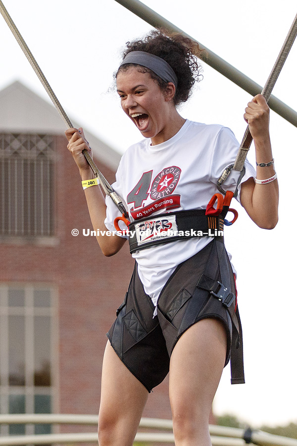 Khea Demery reacts as the Flyer lifts her into the air for the first time. Students flip spin and jump on the flyer as part of the Back to School Bash on the Nebraska Union Plaza and Green Space sponsored by Campus NightLife. Students enjoyed a headphone