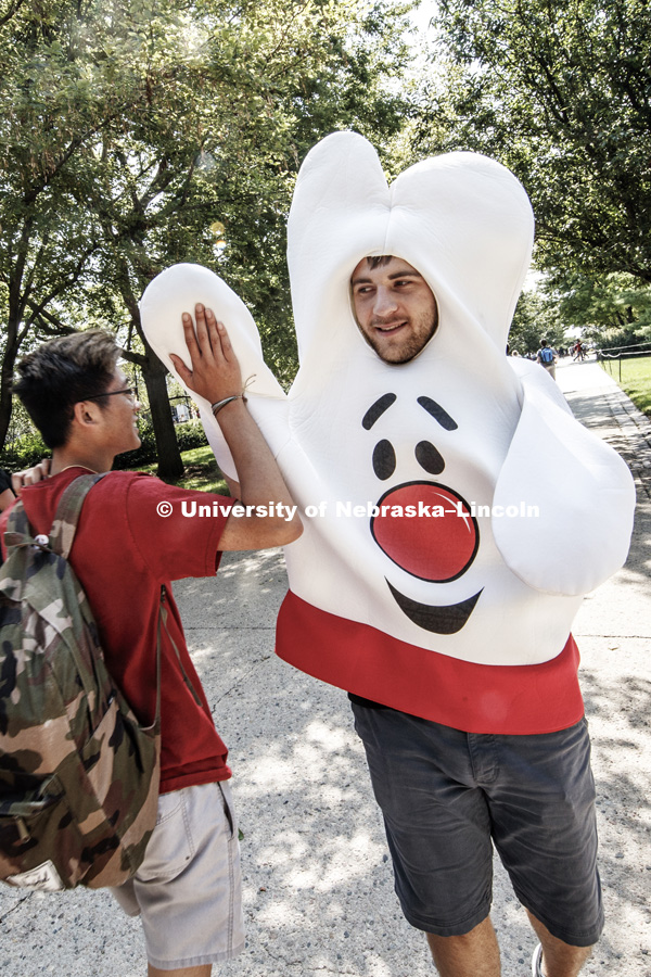 Seth Woods gives a student a hand--sort of--as he and others with the Character Council have a High Five Friday during the lunch hour north of the union. August 25, 2017. Photo by Craig Chandler / University Communication.