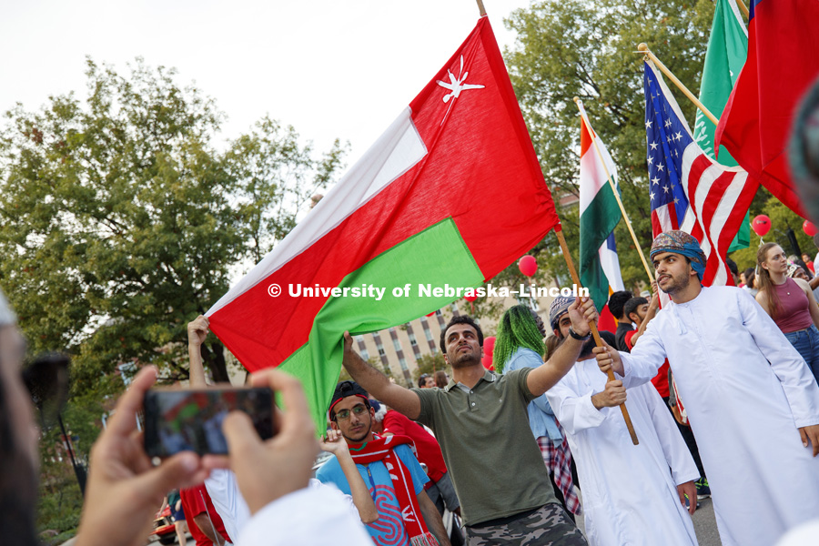 Students from Oman pose with their flag for a photo after the parade. Homecoming parade, pep rally and court jester competition. September 22, 2017. Photo by Craig Chandler / University Communication.