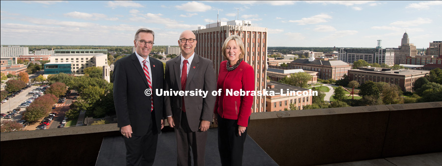 Chancellor Ronnie Green with Vice Chancellors Donde Plowman and Michael Boehm standing on top of a building with the University of Nebraska – Lincoln City Campus in the background. October 10, 2017. Photo by Greg Nathan, University Communication.