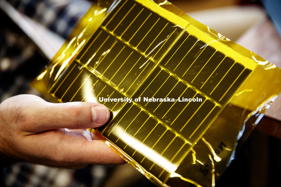 Flexible solar panel's will be deployed with a carbon fiber boom in the student's design. The panels are encased in a yellow Mylar. For the upcoming NASA vibration test, a mock panel will be used. Engineering students have designed a satellite payload to