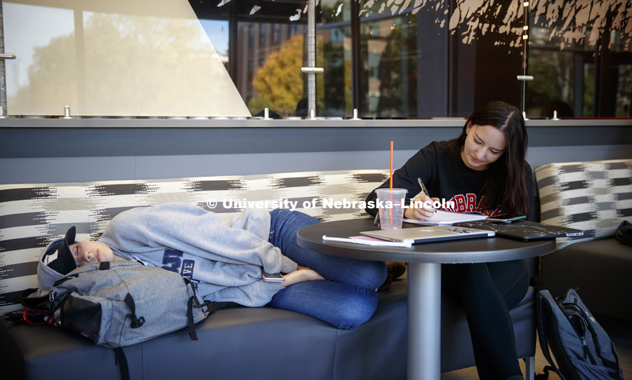 Payton Geschke works on chemistry homework while her friend, Kailey Wiskus, works on a nap in Love Library's Adele Coryell Hall Learning Commons. City Campus fall day. October 25, 2017. Photo by Craig Chandler / University Communication.