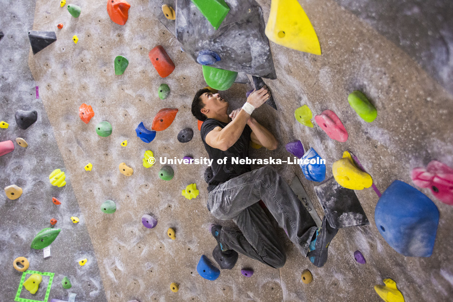Neng Huynh traverses the wall. The League of Extraordinary Boulderers features three-member teams traversing 20 ever-changing routes on the bouldering wall in the Campus Recreation facility on City Campus. The program is designed to teach participants