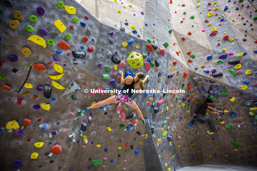 Svetlana Dudin clings to the bouldering wall. The League of Extraordinary Boulderers features three-member teams traversing 20 ever-changing routes on the bouldering wall in the Campus Recreation facility on City Campus. The program is designed to teach