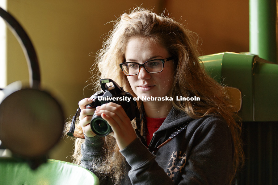 Emily Frenzen, a sophomore from Fullerton, eyes a John Deere tractor she is photographing. Students in Jamie Loizzo's ALEC 240 - Digital Photography and Visual Communication for Agriculture and the Environment practice their photography during a field