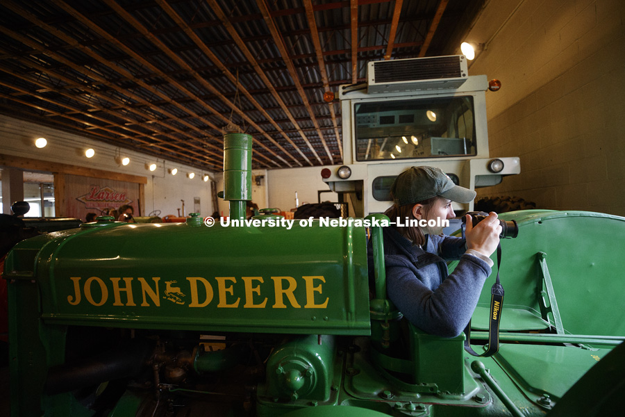 Callie Austad, a senior from Omaha, composes a photo of a John Deere tractor. Students in Jamie Loizzo's ALEC 240 - Digital Photography and Visual Communication for Agriculture and the Environment practice their photography during a field trip to the