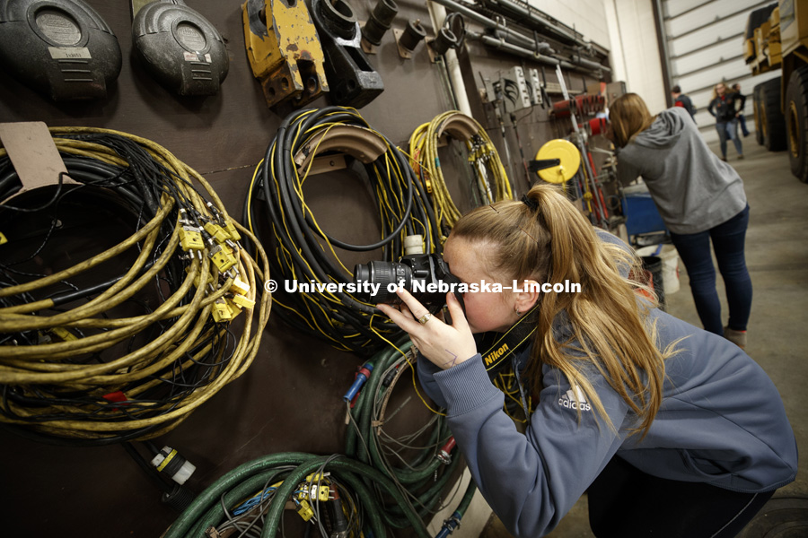 Alice Akers composes an unusual angle on equipment hanging in the tractor test lab. Students in Jamie Loizzo's ALEC 240 - Digital Photography and Visual Communication for Agriculture and the Environment practice their photography during a field trip to
