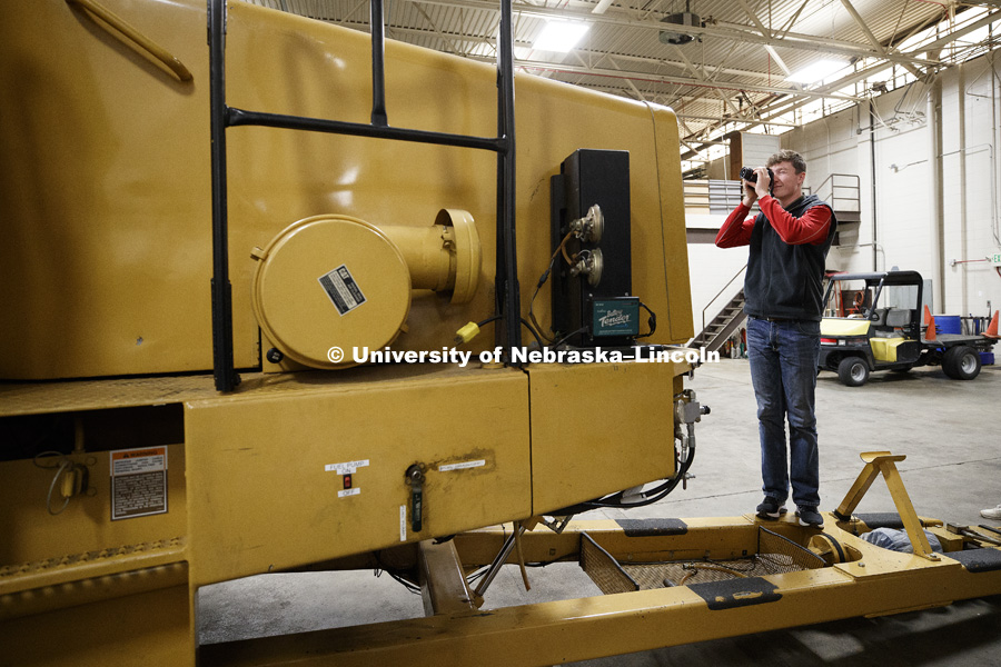 Matthew Morton photographs the front of the tractor test lab's dynamometer car. Students in Jamie Loizzo's ALEC 240 - Digital Photography and Visual Communication for Agriculture and the Environment practice their photography during a field trip to the