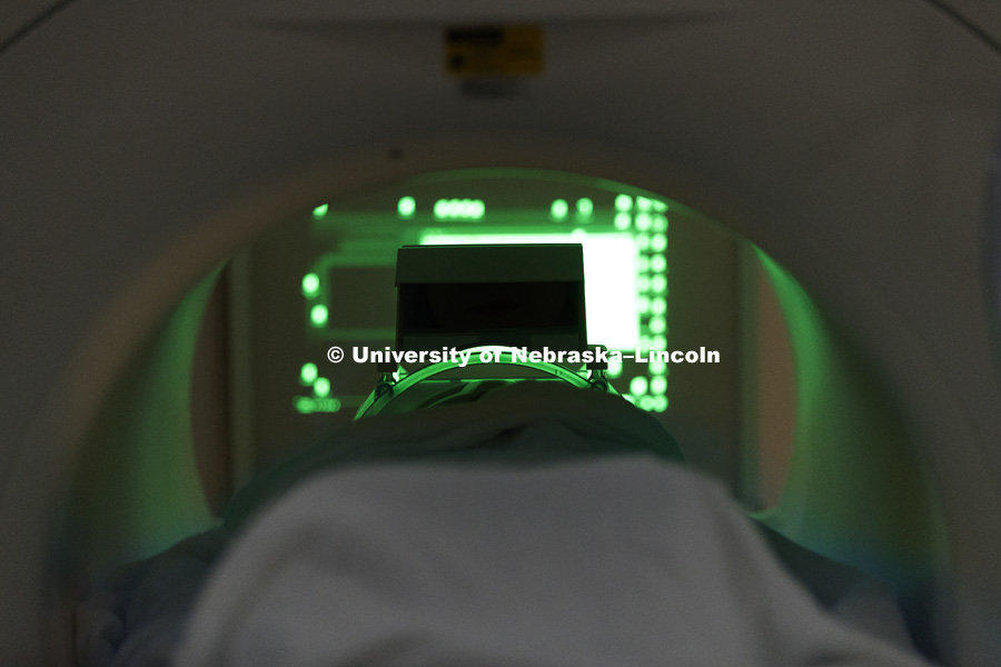 Samantha Lauf lays inside the tube of the MRI. She uses a finger pad to answer questions during a MRI. She can see the computer screen at the end of the tube by a mirror box atop her head stabilizer. Haas is using CB3's MRI technology to study political