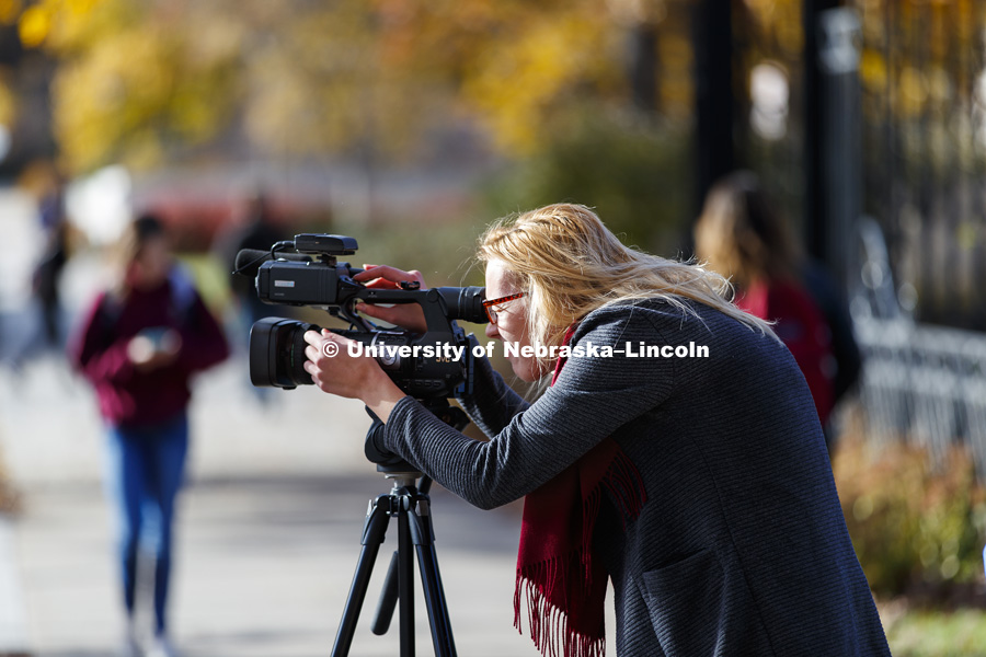 Nela Krawiecova, works on her digital media assignment as she films along R Street. November 15, 2017. Photo by Craig Chandler / University Communication.