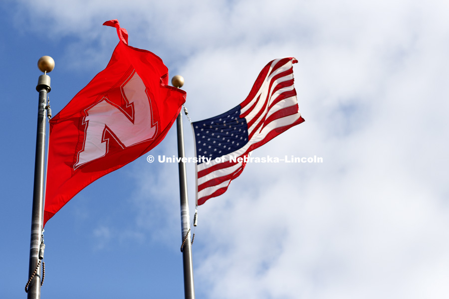 Nebraska and United States flags whip in a north wind alongside the Nebraska Union. November 21, 2017. Photo by Craig Chandler / University Communication.