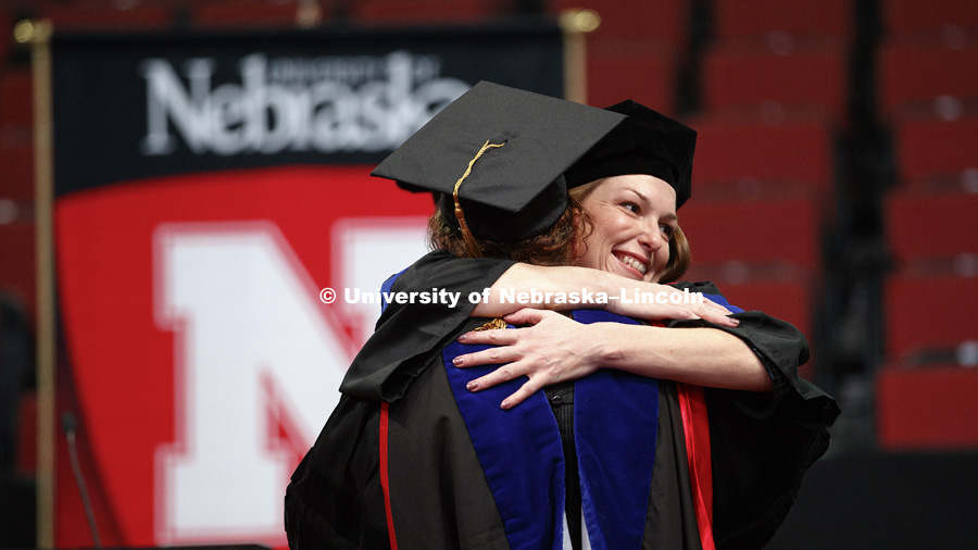 Angela Fedon is hugged after she received her Doctor of Philosophy in Educational Studies. Graduate Commencement and Hooding ceremony. December 15, 2017. Photo by Craig Chandler / University Communication.