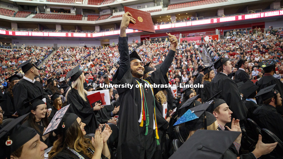 Nadir Al Kharusi shows off his diploma to family and friends Saturday.  Al Kharusi, from Oman, stood after Chancellor Green asked first Nebraska residents, then non-Nebraska residents and finally international graduates to stand and be recognized.