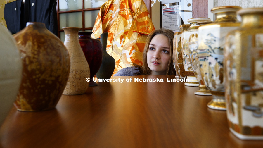 Anastasia Dehtyarenko, a sophomore in global studies and Japanese, from Magnitogorsk, Russia, looks over the pottery from the Lentz Collection Art Exhibit on display in the Kawasaki Reading Room. Gaughan Multicultural Center. January 30, 2018. Photo by