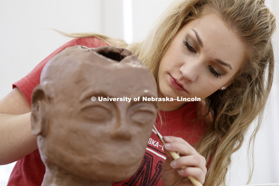 Emma Lichtenfeld, a freshman from Lincoln, works on a clay bust in Richards Hall. January 31, 2018. Photo by Craig Chandler / University Communication.