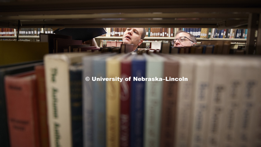 Peter Capuano, associate professor of English and director of the 19th-century studies program, and Andrew Stauffer of the University of Virginia and founder of Book Traces, search one of the basement shelves. The basement of Love Library north filled