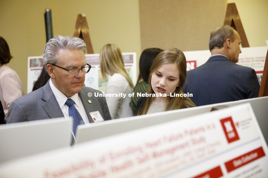 Senator Jim Scheer listens as Bailey Barnes explains her research on Trust in the Jury System as a Predictor of Juror/Jury Decisions. State Senators Research Fair at the Capitol. April 10, 2018. Photo by Craig Chandler / University Communication.