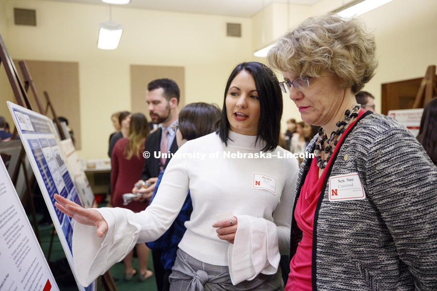 Senator Sue Crawford listens as Jayden Barth explains the effects of prior education on the success of inmates in prison education programs. State Senators Research Fair at the Capitol. April 10, 2018. Photo by Craig Chandler / University Communication.