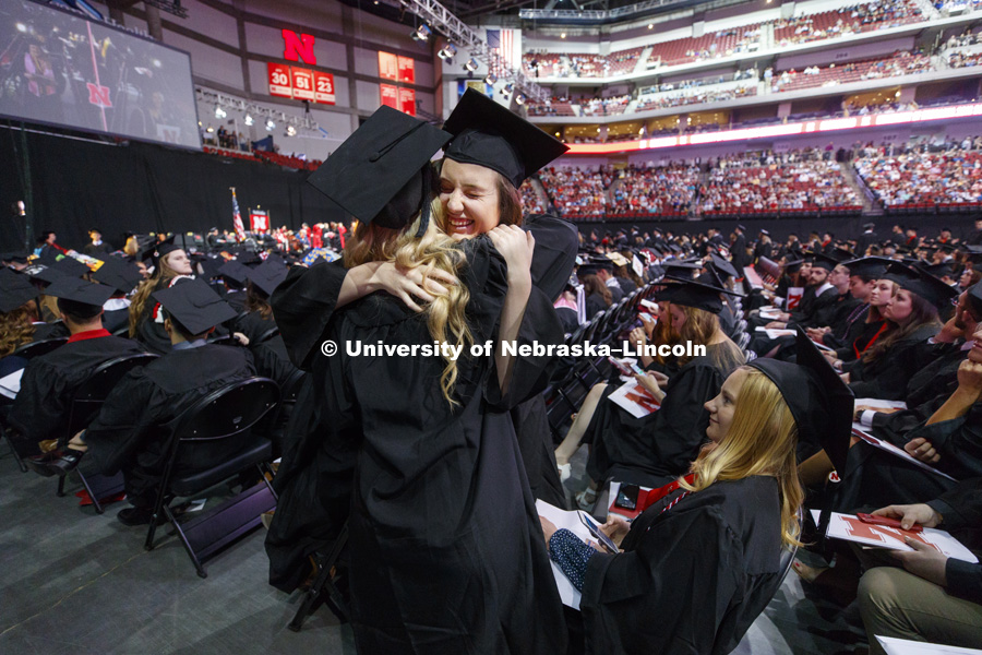 Caitlin Gehner receives a hug from Sarah Pogue as the Arts and Sciences graduates receive their degrees and return to their seats. Undergraduate Commencement at Pinnacle Bank Arena. May 5, 2018. Photo by Craig Chandler / University Communication.