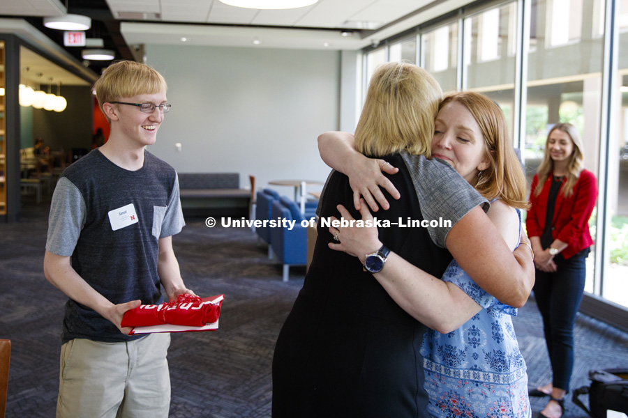 Sam Harvey receives a full ride scholarship offer the university presented by Executive Vice Chancellor Donde Plowman. Sam's mom, Elisia Flaherty, at right, hugs Executive Vice Chancellor Plowman after the ceremony. Sam is a high school junior from Grand