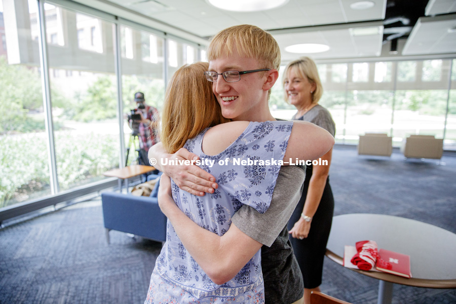 Sam Harvey receives a hug from his mom, Elisia Flaherty, after receiving a full ride scholarship offer the university presented by Executive Vice Chancellor Donde Plowman. Sam is a high school junior from Grand Island and scored a perfect ACT score. June