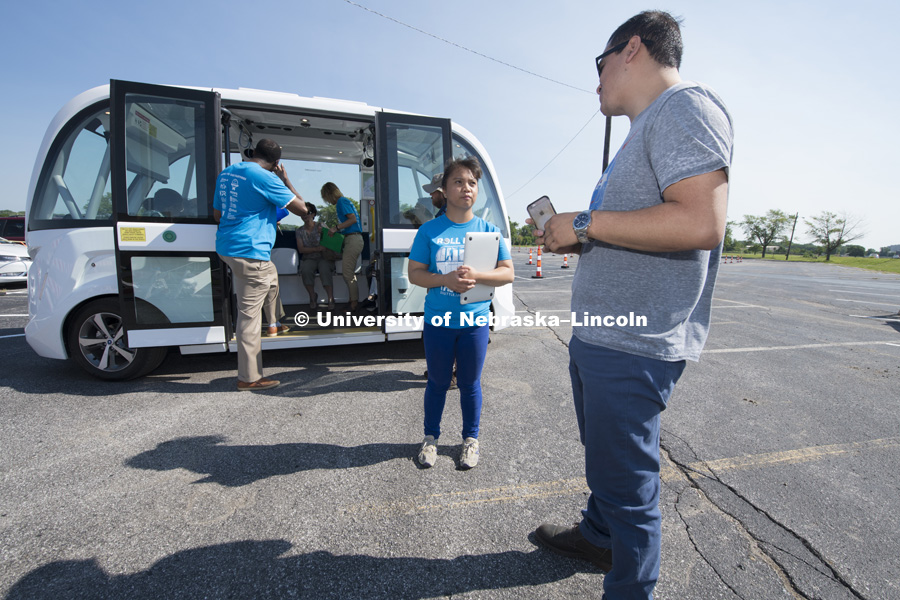 Amanda Kelebit, graduate research assistant for Facilities, Maintenance and Planning Utility Services, conducts a survey on what people think of the autonomous vehicles. July 9, 2018. Photo by Greg Nathan, University Communication Photography.